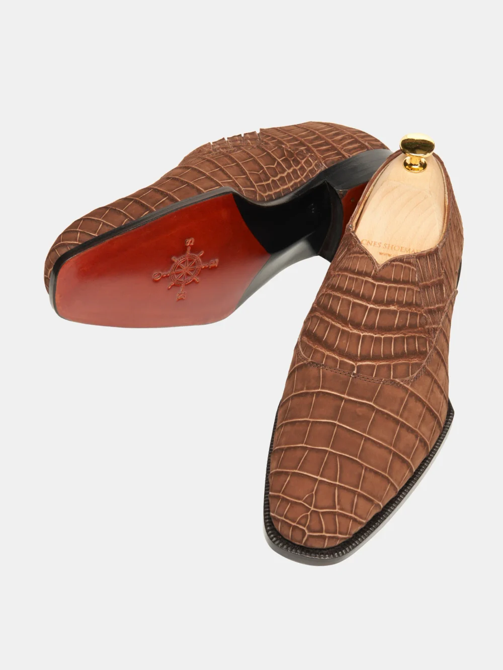 Brown crocodile nubuck shoes with a sleek design and contrasting black sole.