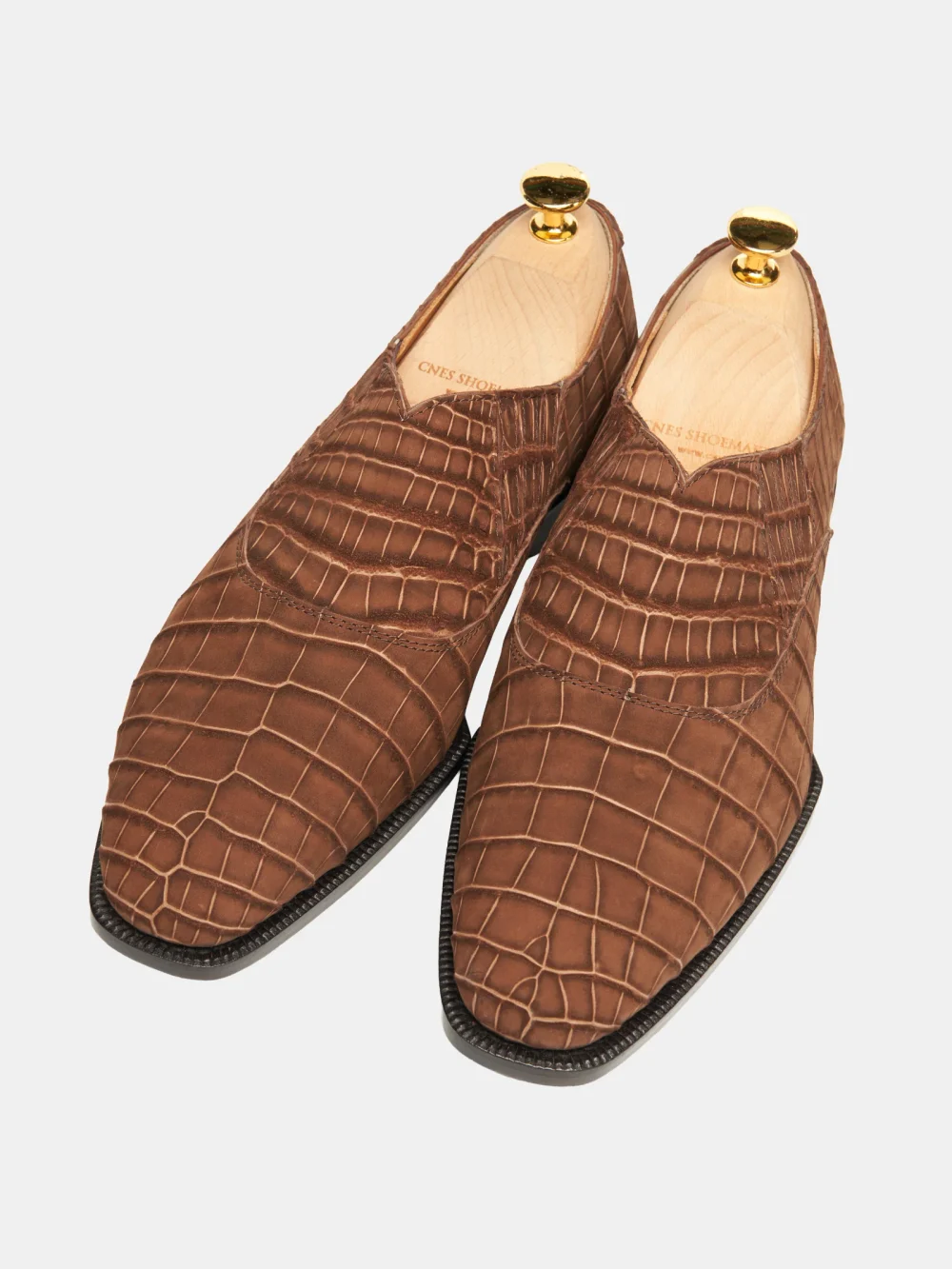 Brown crocodile nubuck shoes with a pointed toe design and gold shoehorns.