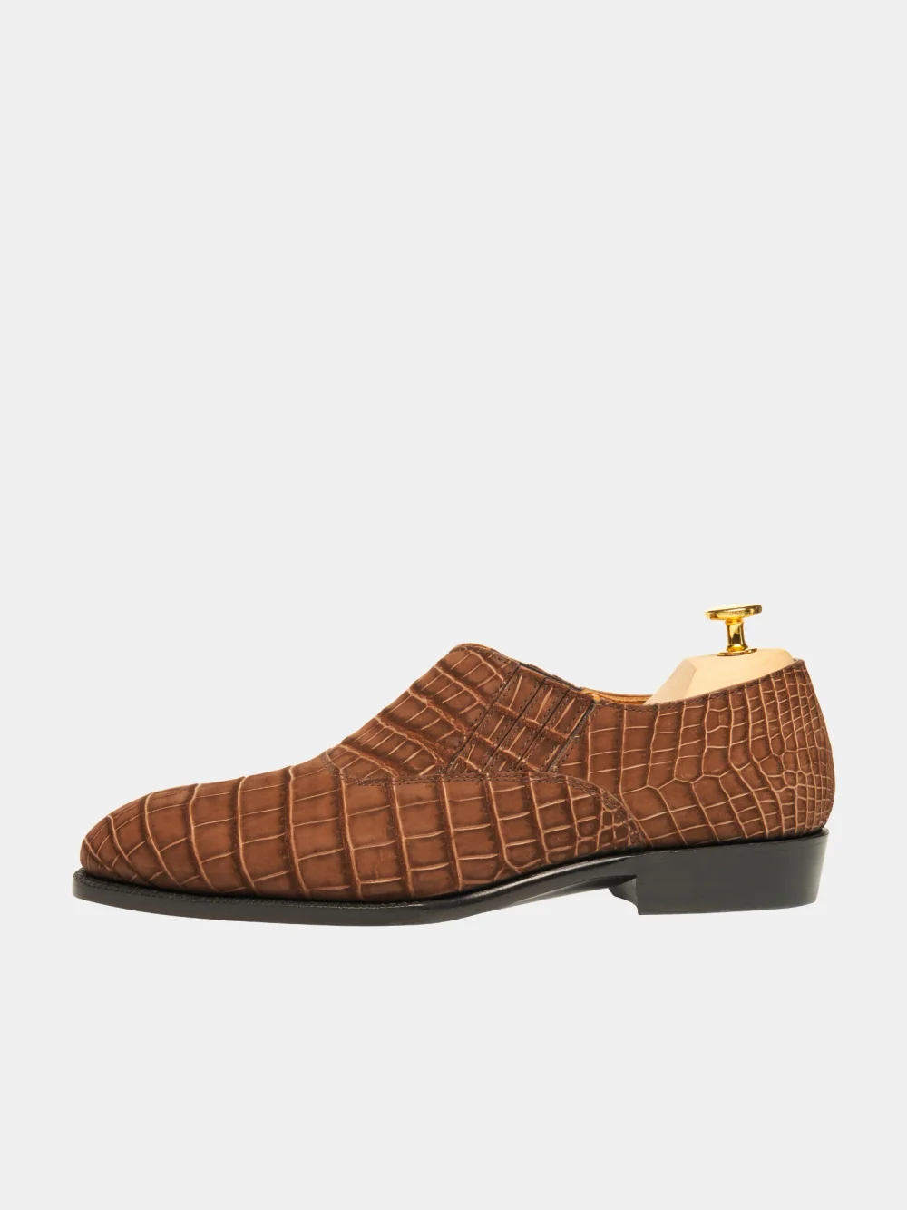 Brown crocodile nubuck shoe with a low heel and a shoe tree inside.
