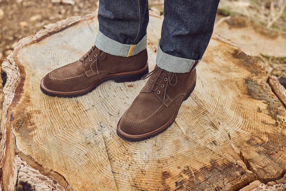 Brown suede boots with laces are worn with rolled denim jeans.