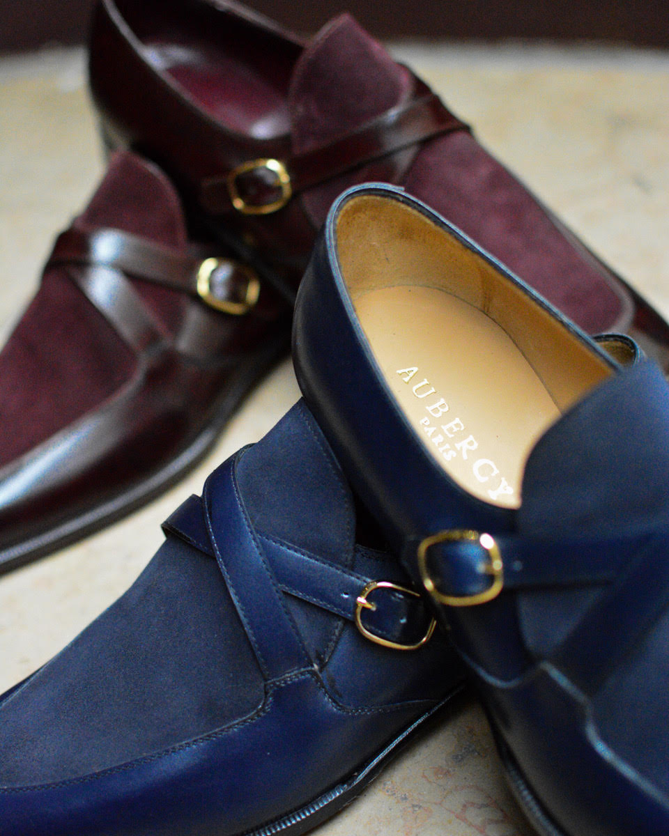 Aubercy shoes in dark blue and burgundy leather, featuring gold buckles.