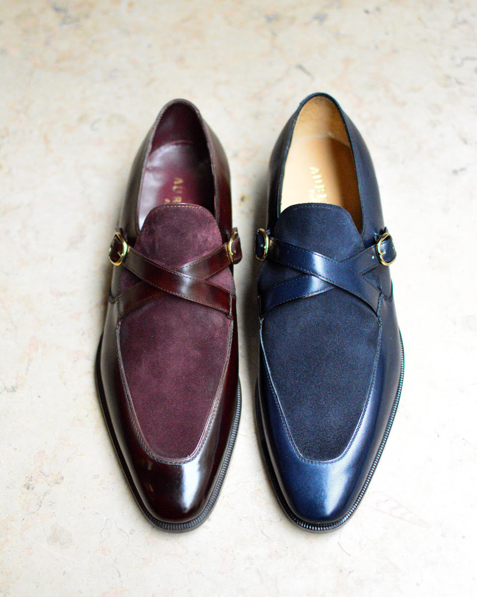 A pair of elegant shoes featuring a burgundy leather and suede design on the left and a navy leather and suede design on the right, both with decorative straps.