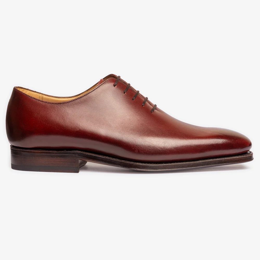 A sleek pair of burgundy shoes with a polished leather finish and a pointed toe design.