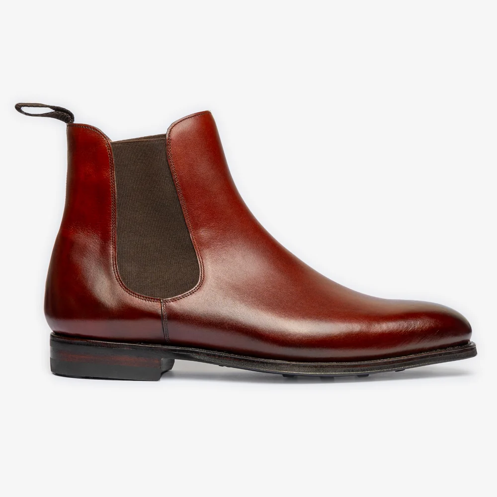 A sleek pair of burgundy leather Chelsea boots with elastic side panels.