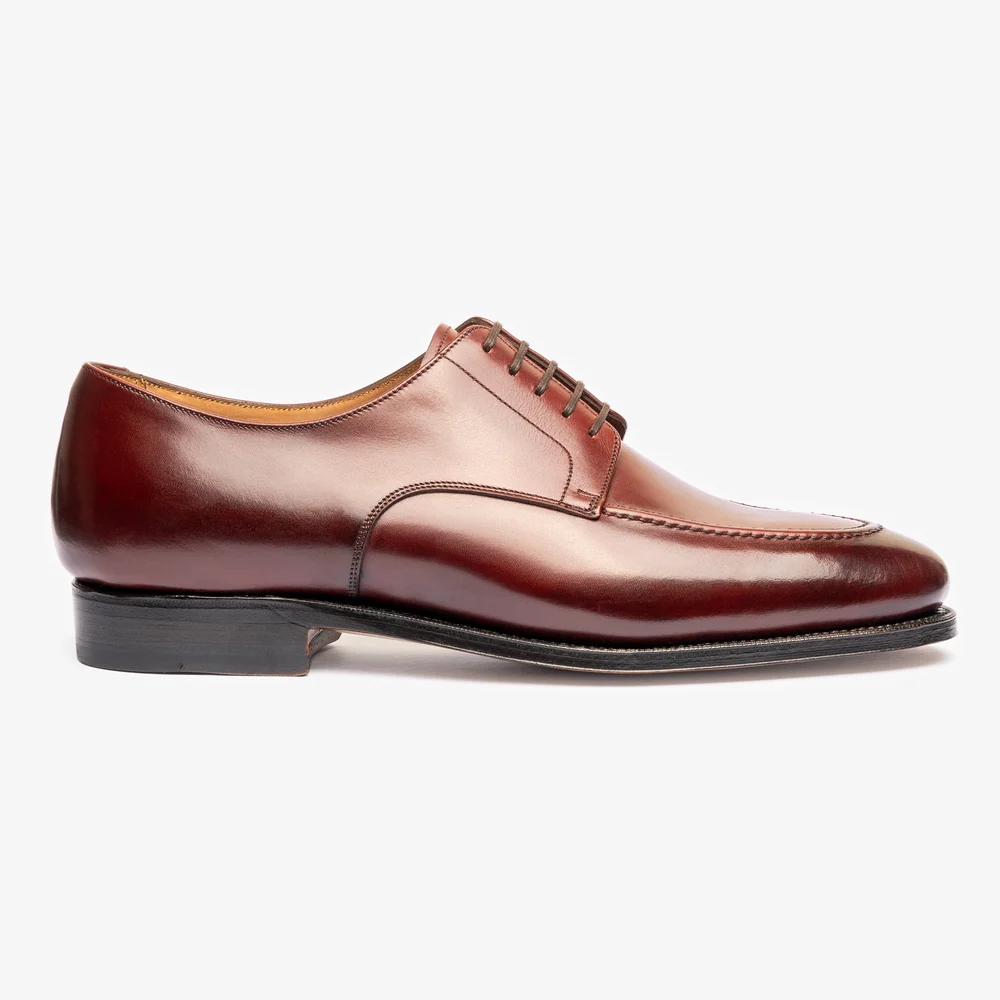A polished pair of burgundy shoes with a sleek design and five eyelets for laces.