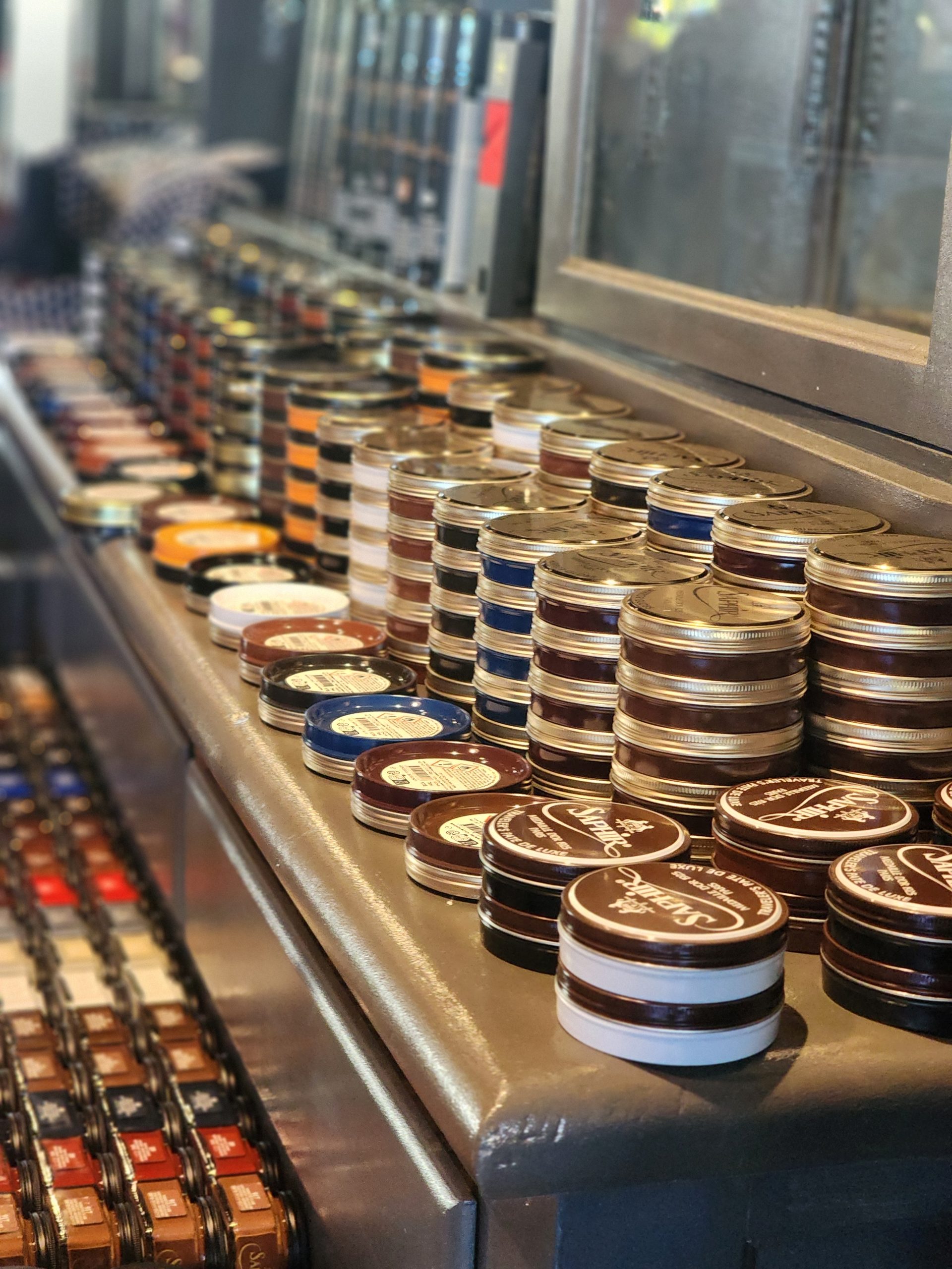 A variety of round tins in different colors and sizes are neatly arranged on a countertop, showcasing products for the Chicago Super Trunk Show x Stitchdown Expo 2026.
