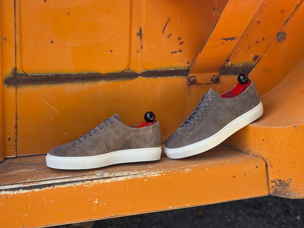 Gray suede sneakers with red insoles and white soles.