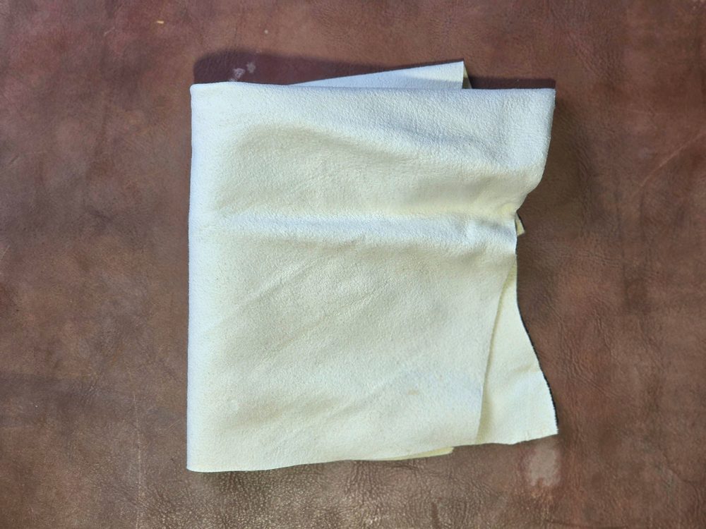 A folded, soft white cloth, likely used for cleaning, featured in the shoe care guide.