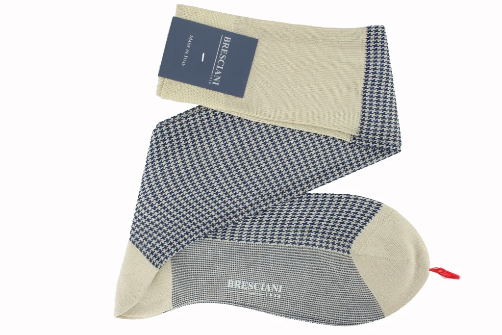 A pair of over-the-calf socks featuring a beige and navy houndstooth pattern, labeled "Bresciani."