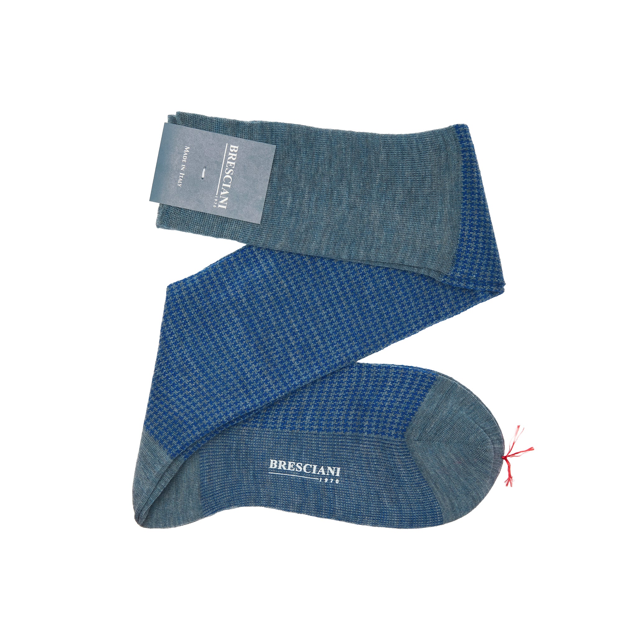 A pair of blue socks with a textured pattern and a label, illustrating the contrast in design for over the calf vs mid calf socks.