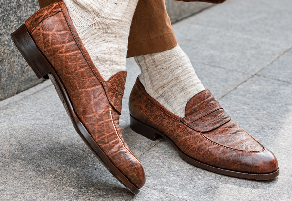 Brown leather loafers paired with light-colored socks.