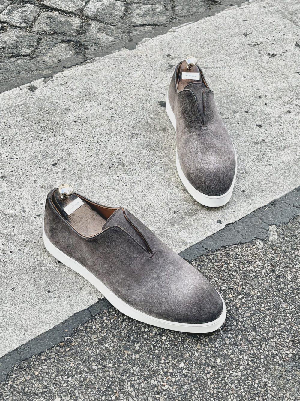 Gray suede slip-on sneakers with white soles.