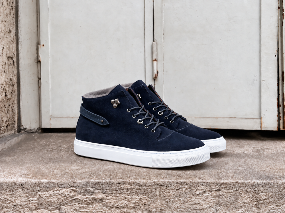 Navy suede high-top sneakers with gray laces and a white sole.