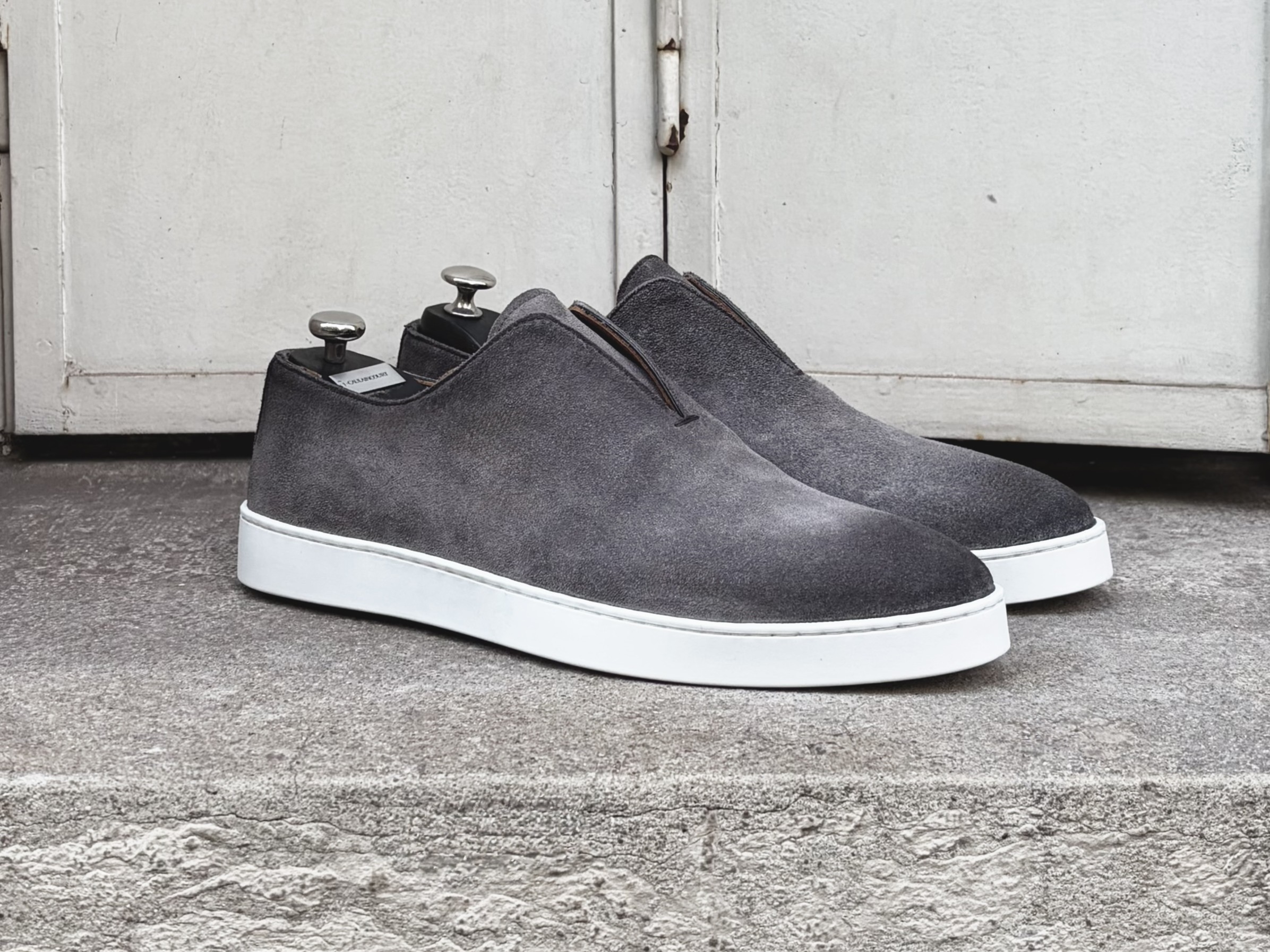 Gray suede slip-on sneakers with white soles.