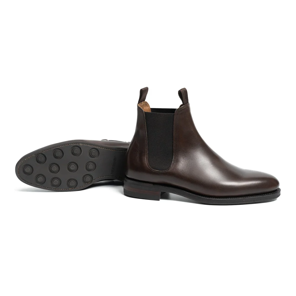 Brown leather Chelsea boots with elastic side panels and a rubber sole.
