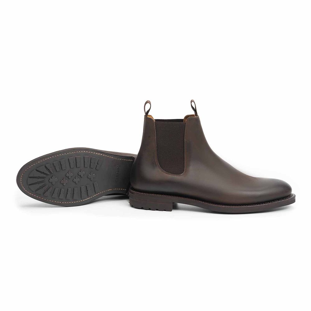 Brown leather Chelsea boots with elastic side panels and a textured rubber sole.