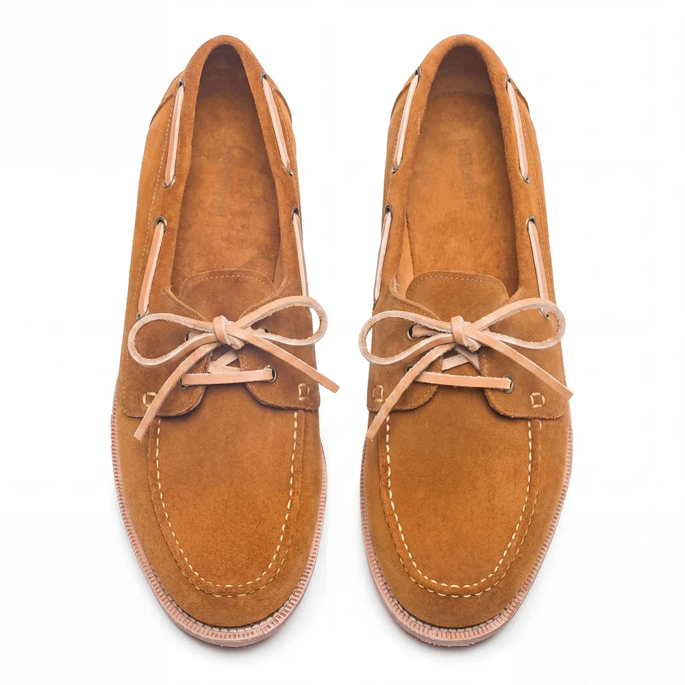 Tan suede shoes with a lace-up design and contrasting stitching.