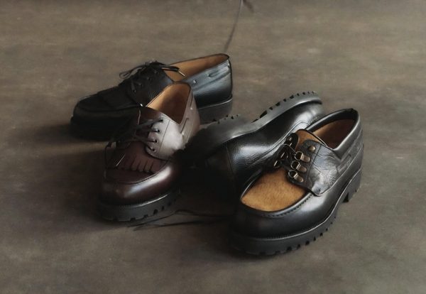 Three pairs of Septième Largeur boat shoes in varying shades of brown and black leather are displayed together.