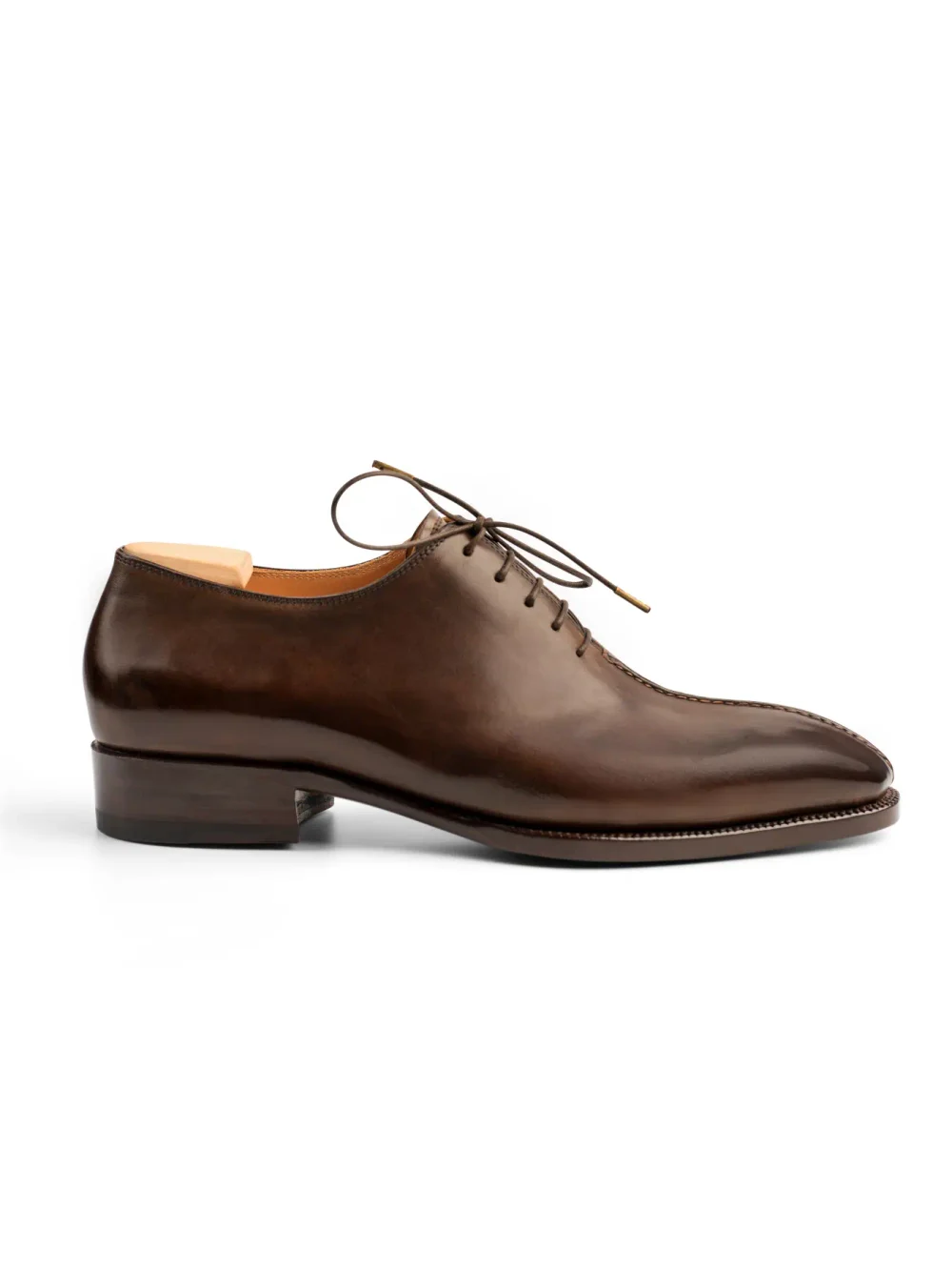 Brown leather dress shoe with a pointed toe and lace-up design.