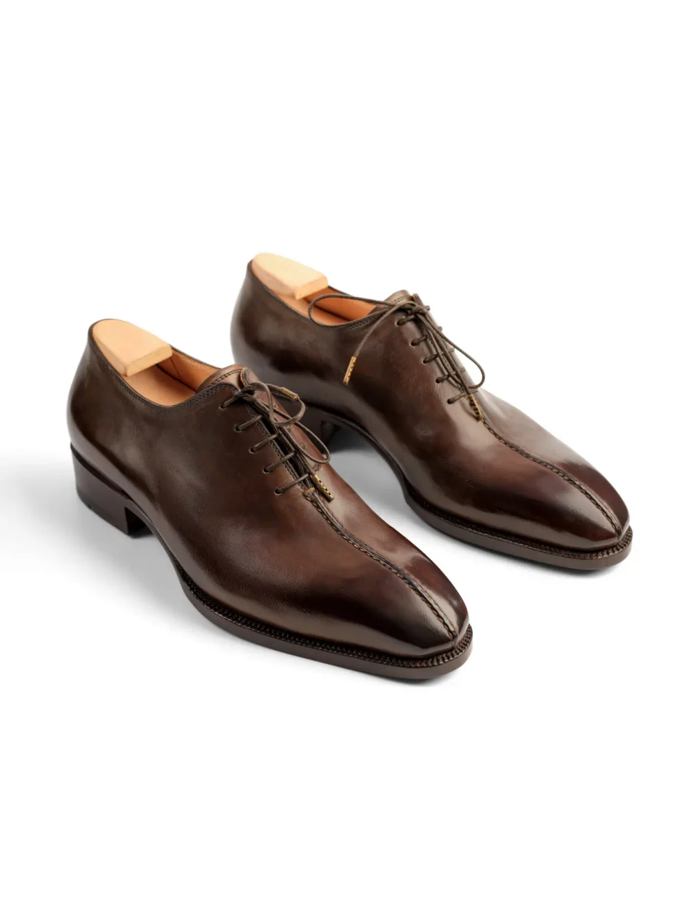 A pair of polished brown leather dress shoes with a pointed toe and lace-up design.