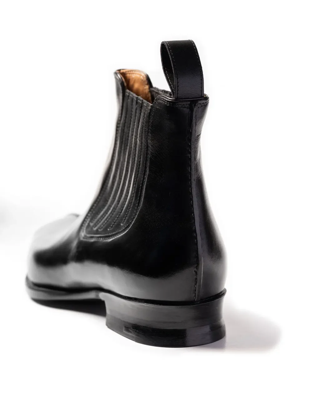A black leather Chelsea boot with a ribbed design and a pull tab at the back.