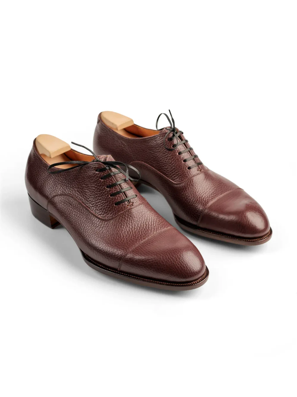 Brown leather dress shoes with a textured finish and lace-up closure.