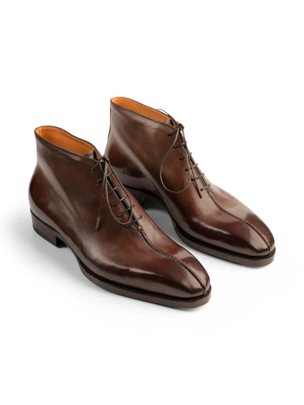 A pair of polished brown leather ankle boots with laces and pointed toes.